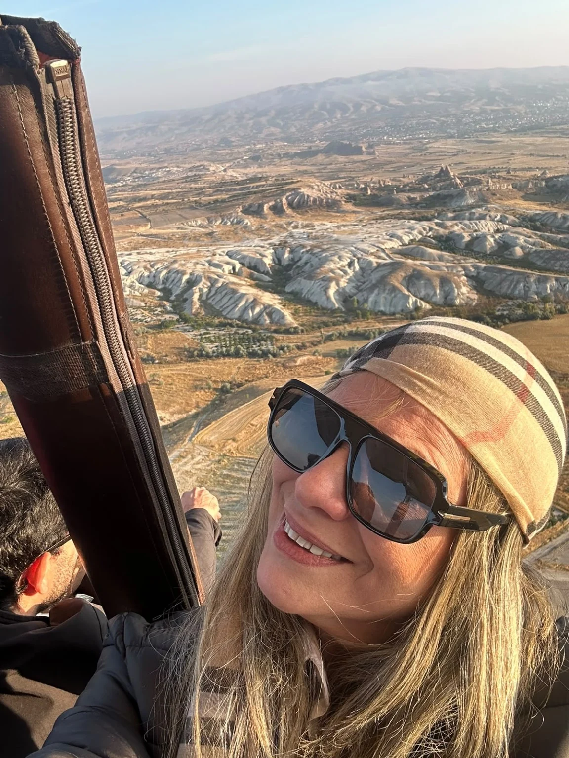 Traveler taking a photo from a hot air balloon basket above Cappadocia