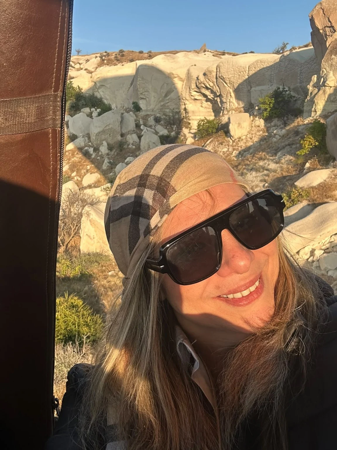 Traveler looking out over Cappadocia white rock formations from hot air balloon